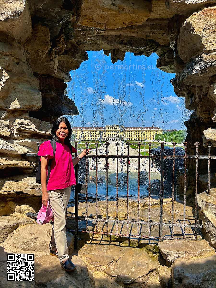 Austria Vienna Schönbrunn woman standing near a waterfall at Neptune Fountain Neptunbrunnen.