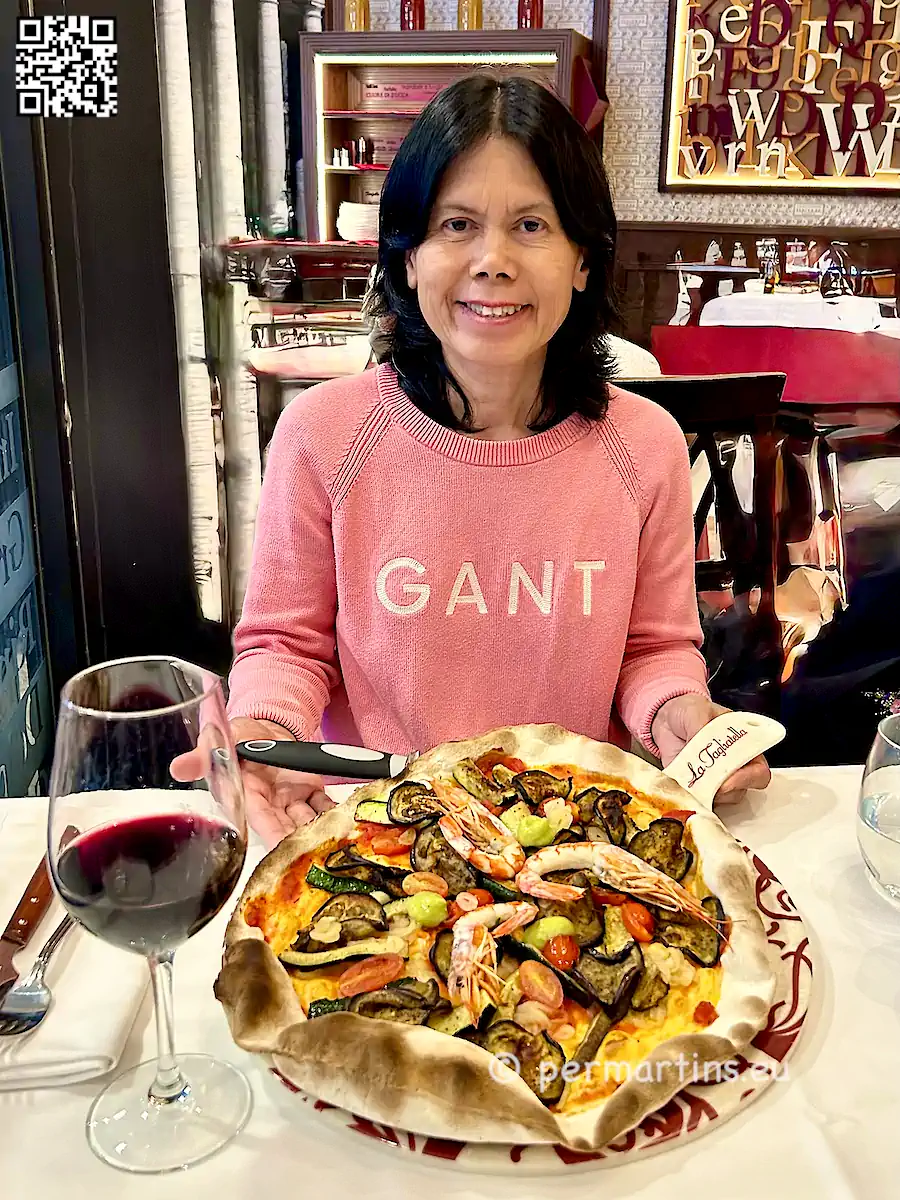 Spain Valencia restaurant La Tagliatella woman eating seafood pizza.