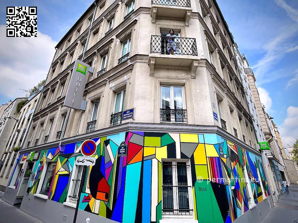 France Paris Ibis Styles hotel, colorful front and entrance, woman on balcony.