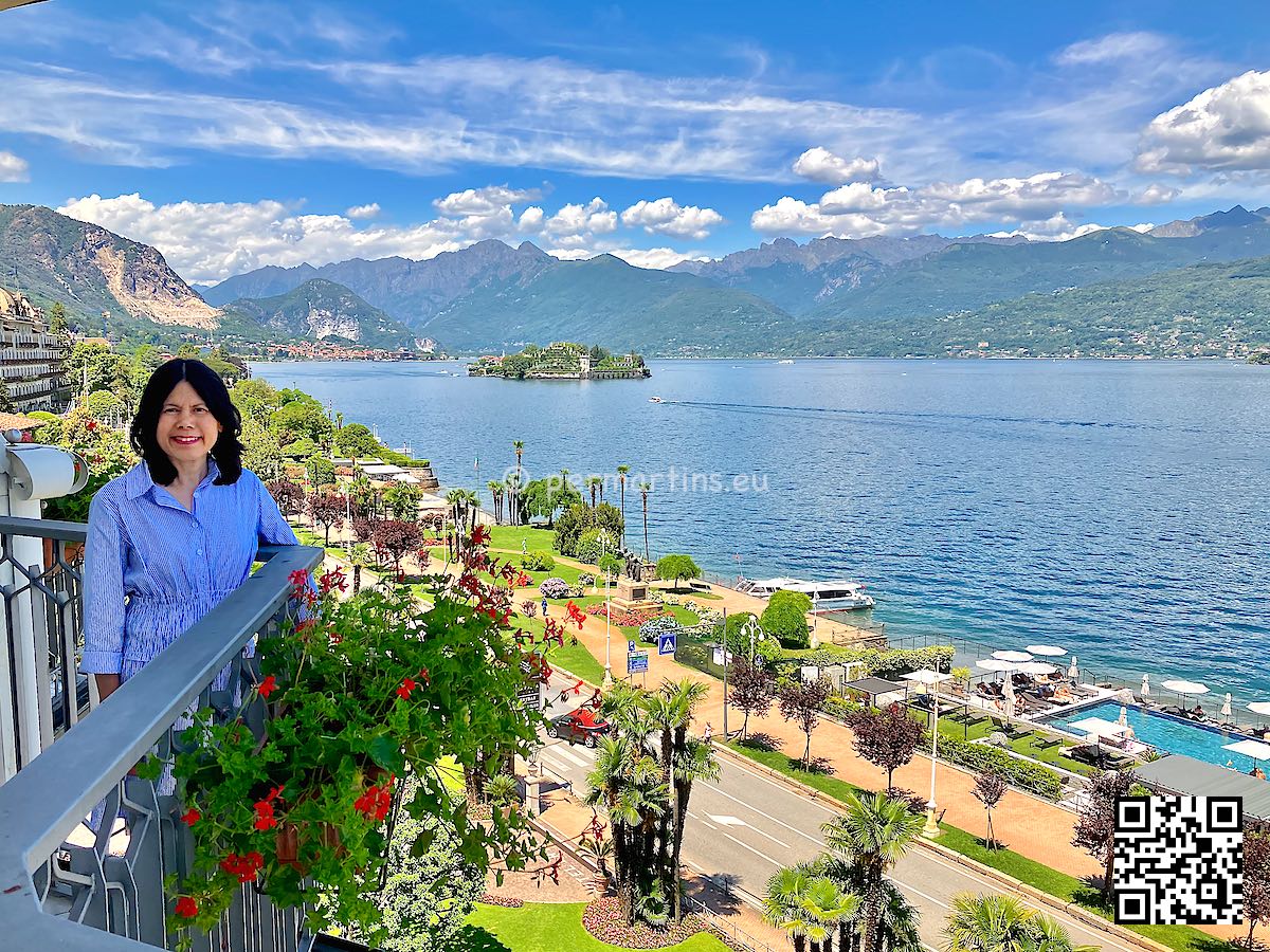 Italy Stresa view over Lago Maggiore from Hotel Astoria, woman on balcony.