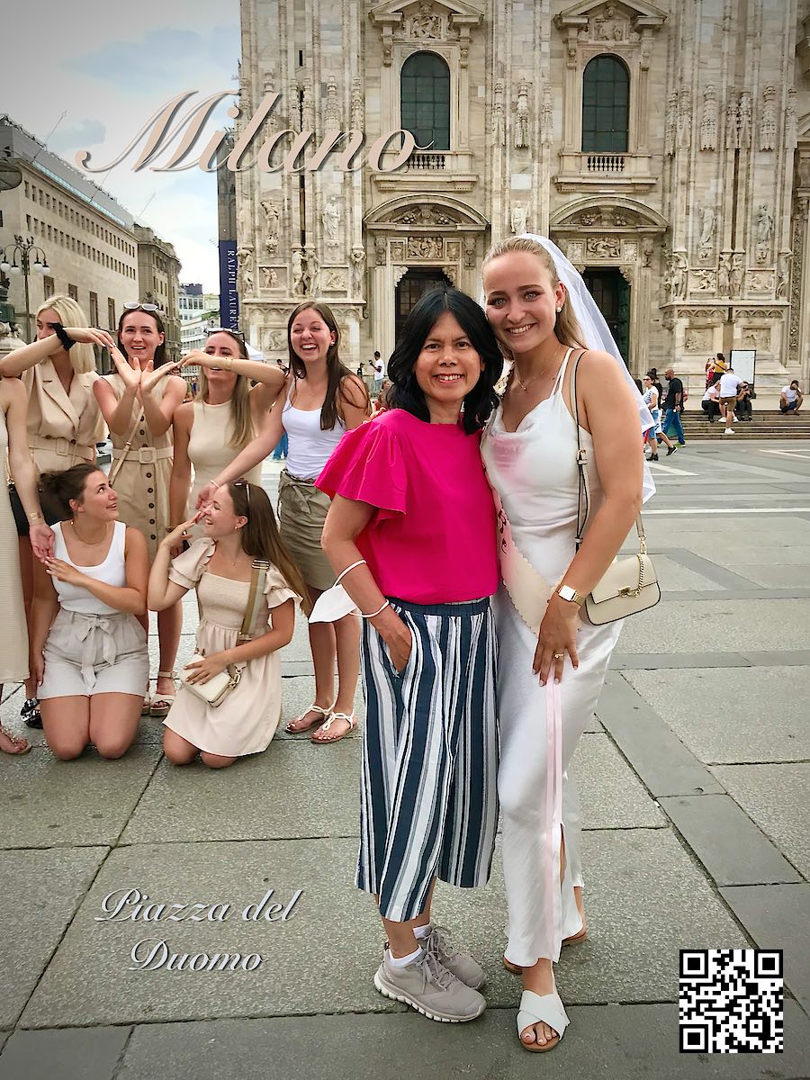 Italy Milano at Piazza del Duomo woman in red next to happy bachelorette party of girls.